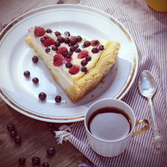 Sunny Photo with a morning breakfast in a rustic style. Cheesecake with raspberries and blueberries on wooden table. Selective focus picture. Square, instagram toned photo