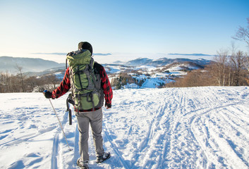 Backpacker hiking on snow covered mountain