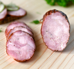 Smoked sausage with herbs on a wooden board