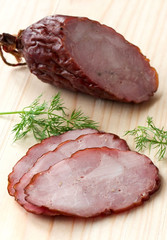 Smoked sausage with herbs on a wooden board