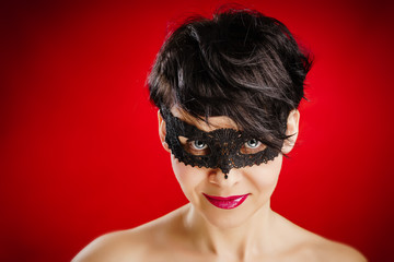 beautiful woman in a black mask looks seductively