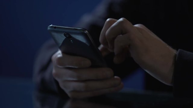 Hands of lonely man scrolling pictures on smartphone, using mobile dating app