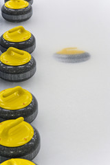 Yellow Curling Stones on ice sheet
