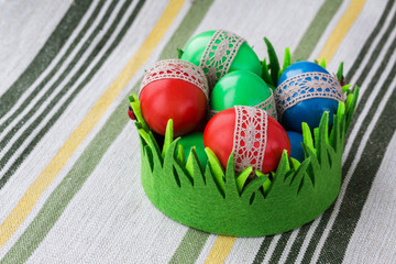 Colorful Easter eggs in green basket.