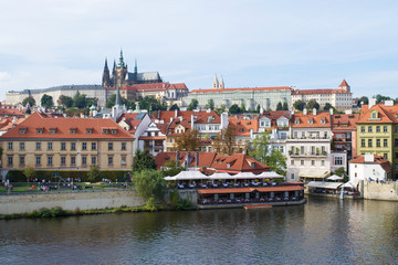 Obraz premium Buildings along the Vltava River under Prague Castle
