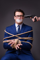 Businessman taken hostage and tied up with rope
