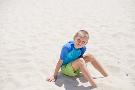 Smiling boy sitting on the beach, Nesebar, Bulgaria