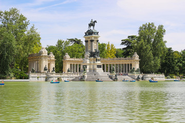 Fototapeta na wymiar Beautiful of tourists on boats at Monument to Alfonso XII in the Parque del Buen Retiro, Park del Retiro, Madrid, Spain