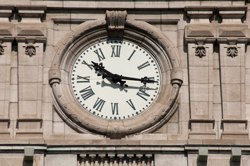 Clock (10:16 am) of City Hall in Old Montreal, Quebec, Canada.  Fleur de Lis embellishments in the...