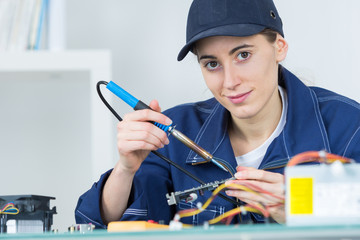Female technician using soldering iron