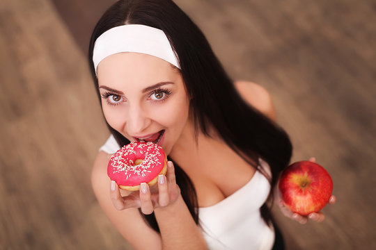Portrait of a gorgeous young brunette woman showing diet food choices.