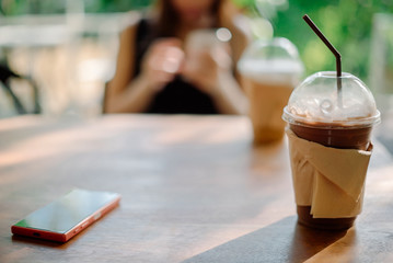 Young woman using smartphone in coffee shop.