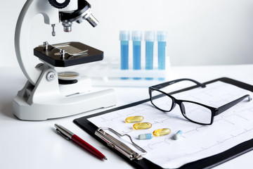 doctors desk with microscope and test tubes