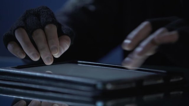 Hacker making cyberattack on computer network, launching malware from tablet pc