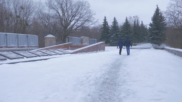 a Young Couple Moving to the Monument to Artyom, Build in 1927, Which is Twenty Meters High, and Standing Behind an Alley of Fir Trees in Winter