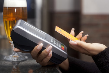 Woman pay with credit card in bar