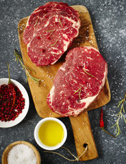 Fototapeta na wymiar Raw fresh meat Ribeye Steak with rosemary, pepper, salt and oliv