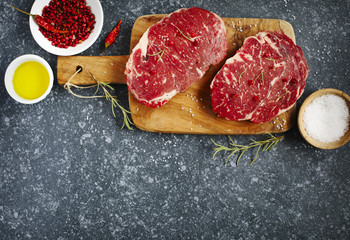 Raw fresh meat Ribeye Steak with rosemary, pepper, sea salt and