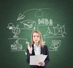 Woman with documents and MBA sketch, blackboard
