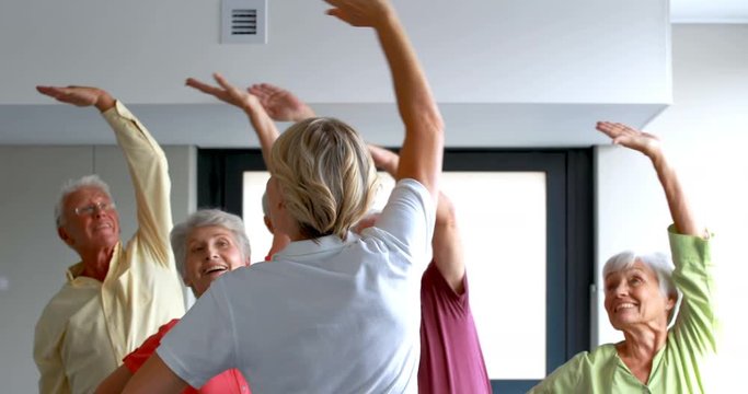 Trainer assisting senior citizens in exercising