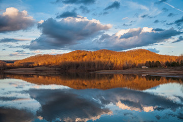 Fototapeta na wymiar Mountain Water Reflection on Lake During Sunset