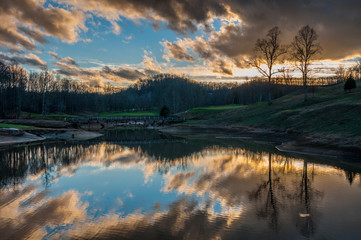 Fototapeta na wymiar Cloud Reflection on Lake at Golf Course with Bridge