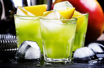 Green cocktail with mango, black background, selective focus