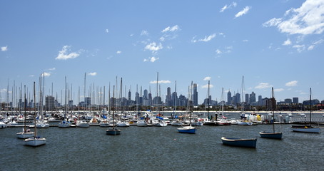 Fototapeta na wymiar Melbourne skyline from St Kilda (Victoria Australia). View from a wooden jetty over the city of Melbourne in the Port Phillip Bay in Victoria and many yachts on the quay.
