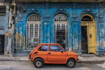 old small car in front old blue house, general travel imagery, on december 26, 2016, in La Havana, Cuba - obrazy, fototapety, plakaty