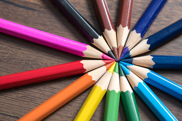 Fototapeta premium Color pencils on wood background