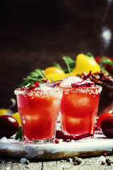 Tomato cocktail with pepper vodka, orange juice and ice, wooden