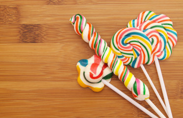 Colorful lollipops on wooden background with room for text 