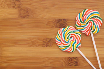 Colorful lollipops on wooden background with room for text 