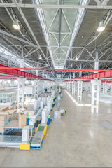 factory floor for production and assembly of household refrigerators on the conveyor belt. factory workers collect refrigerators on the conveyor belt