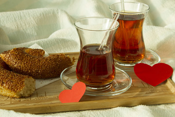 Morning turkish tea in traditional glass with bagel on the tray,