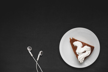 Chocolate cake with headphones on a black background