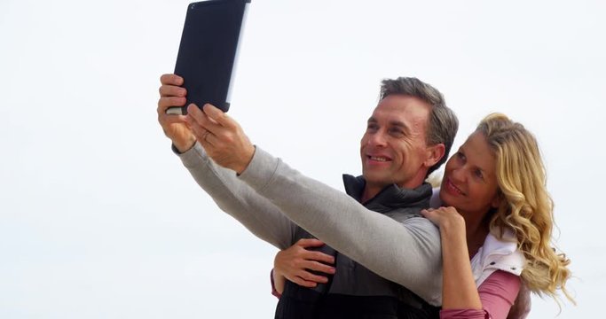 Mature couple taking a selfie from digital tablet