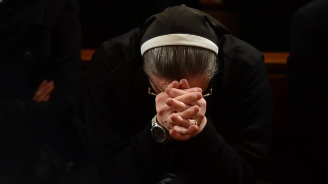 Catholic nun praying in church