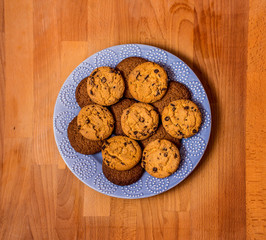 Christmas or Valentine cookies on blue plate. Gingerbread cookies on vintage wooden background. Chocolate  biscuits, spices over wooden background. Top view