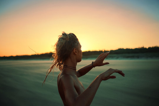 Woman dancing in the sunset on the beach