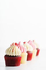 colorful cupcakes on white wooden background