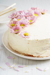 Fototapeta na wymiar sweet white buttercream cake with pink flowers on top