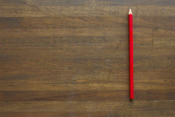 red pencil on wooden background