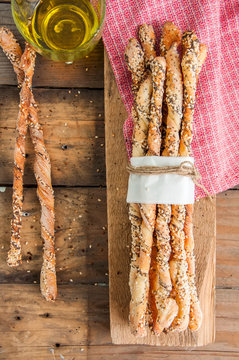 Fresh baked homemade grissini bread sticks on a wooden board