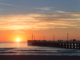 People walking on Forte dei Marmi's pier at sunset