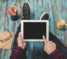 Close up young man holding white tablet with copy space
