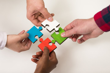 business people group assembling jigsaw puzzle and represent team support