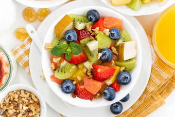 breakfast with fruit salad and corn flakes on table, top view