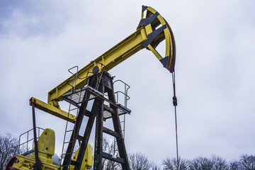 Small private yellow derrick pumps oil.