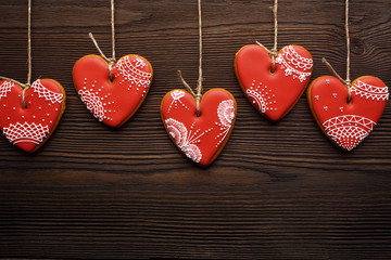 Line of red gingerbreads hearts on ribbon.